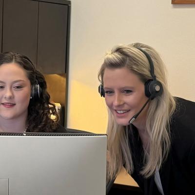 photo  of two member service representatives interacting with each other in front of a computer