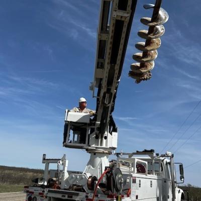 Photo of TCEC linemen performing work in a bucket truck