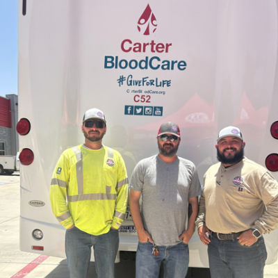 Photo of TCEC employees posing with the Carter BloodCare mobile donation bus